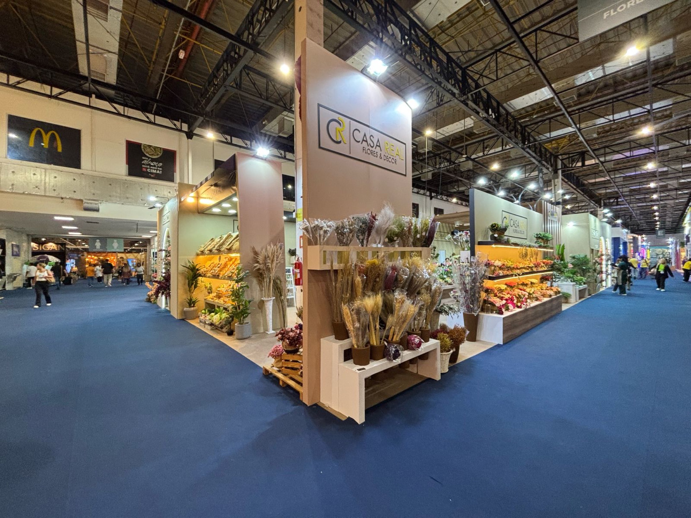 Stand da Casa Real na ABCasa, com fachadas claras e mostruários de flores e arranjos