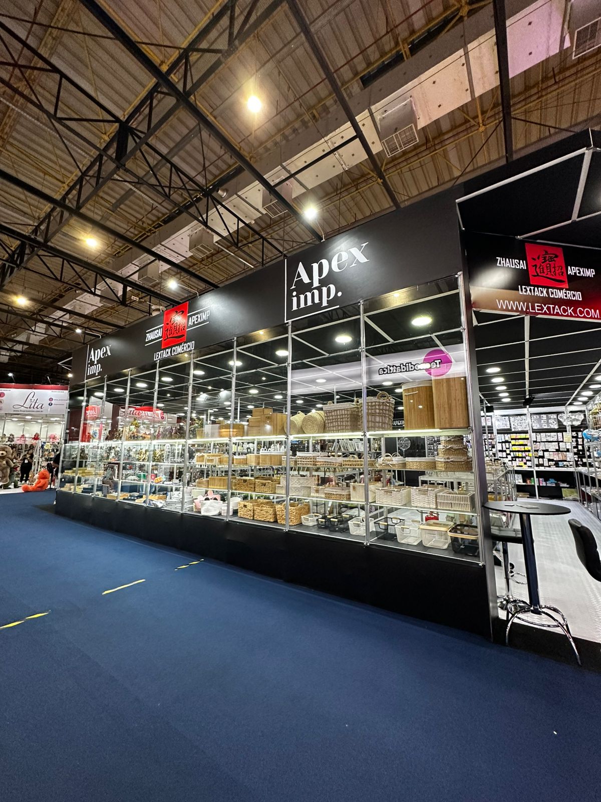 Stand padrão da Lextack, com estrutura modular preta e vitrines para exposição de produtos