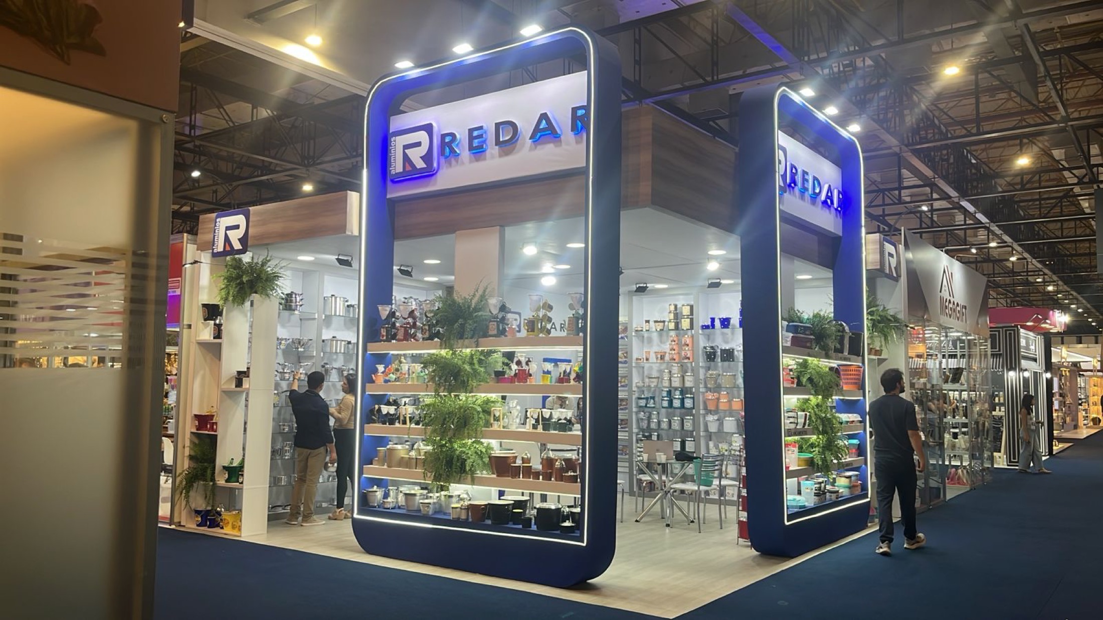 Stand da Redar na ABCasa, com pórticos azuis iluminados e vitrines de utensílios domésticos